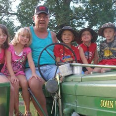 Dad on his tractor with 5 of his grandchildren Jocelyn, Bobbi, Dad(Duffy), Ridge, Preston, William