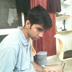 In hostel room- busy with his laptop.