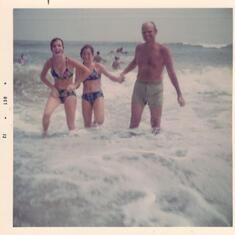 Dad was always up for a fun time. Here he is catching the waves with Judy and Patti