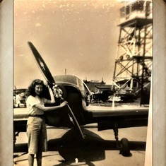 Guessing Mom is standing in front of either Dad or Uncle Charley's plane.