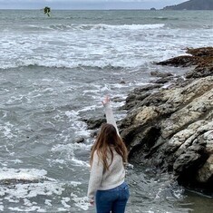 Sabrina tossing in Anne's favorite flower, the Sunflower, at the Shell Beach, also her favorite.