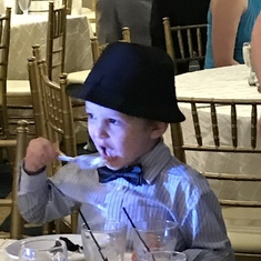 Ethan enjoying wedding cake Love his hat!