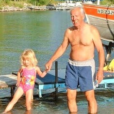 Tanned Arvin at lake home with posing granddaughter, Cassandra Hagen.