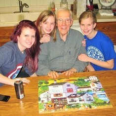 Arvin in the kitchen of his Fargo townhome (Christmas, 2013), surrounded by granddaughters Emily, Amanda and Cassandra  and a puzzle they'd completed together.