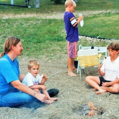 Cooking over a fire at the lake:  son-in-law, Darrel, and Arvin's oldest 3 grandchildren:  cousins Sam, Erik & Audra.