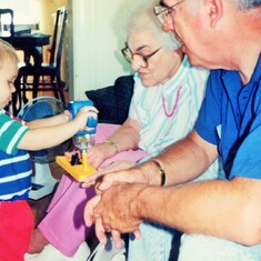 Sam, showing Great-Grandma, Hazel (Drinkwine) Hagen, and Grandpa, Arvin, how his toy drill works (1991).