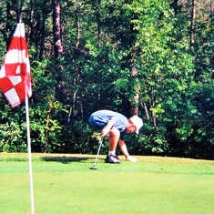 Another photo of Sam golfing with his Grandpa (2001).