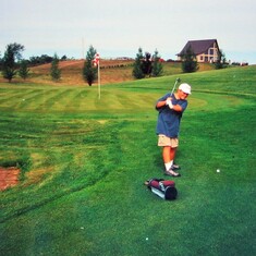 Sam Lukas, golfing with his Grandpa Arvin in 2001.