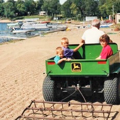 Arvin driving his 3 oldest grandchildren in his 4-wheeler: cousins Sam, Erik & Audra (1992).