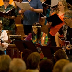 Audrey singing and playing guitar in concert with Edmonton Metropolitan Chorus