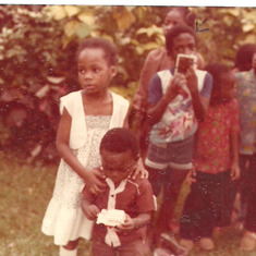Buky holding Lanre with friends in the background