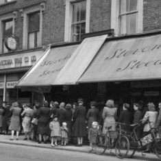 Shoppers wait patiently in a queue. This photo was taken in London in 1945. There had been rationing