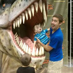 Chad holding Parker in a dinosaur's mouth . Only Chad !