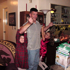 Carlin girls hanging on Uncle Charlie's muscles, Christmas 2002