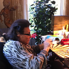 Mimi in her living room checking her mail in her favorite chair.