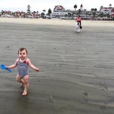 Charlotte watching Rose walk at the beach for the first time, at the Hotel del Coronado.