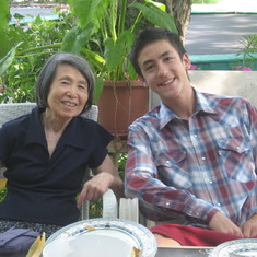 July 2010: Chris with his grandmother's cousin, Li Lianshu of New York City, photo taken on the back deck of the Dennis home in Ithaca.  Chris' two trampolines are in the background as well as elephant ear plants (Colocasia) that had belonged to his great