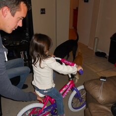 Madelyn got a bike for her bday, it was too dark to ride outside so daddy took her around the house.