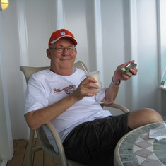 Dave relaxing on cruise balcony 2009 with a pina colada - his traditional sail-away drink.