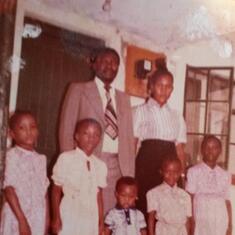 Were Family (early 80s): The Were family early 80's. Front from right Judy Atieno Nyar Were, Lorna Were, Dan Were, Debra Were and the late Madamsi (rip). Back Mr and Mrs Were.