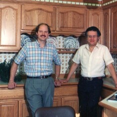 Denis with son Chuck at family business, late '80s