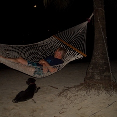 Don "napping" in a hammock, stray island dog as his trusty companion