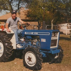 Driving his tractor.