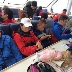Elena, Harriet, Evan, Alex staying out of the wind on the whale watch in Alaska