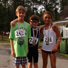Will, Joel, and Kaitlyn T., Emmi's classmates and friends, at the finish. They all ran a strong race for Emmi.
