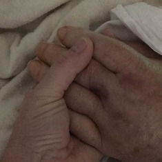 Rhonda holding her Dads hand in hospital.