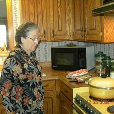 GRANDMA ATTENTIVELY CHECKING THE FOOD