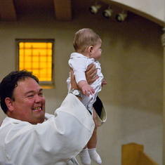 Fr. Rich presents a newly baptized Diego Elias Moro to the congregation.