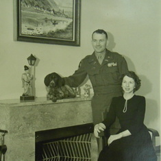 Frank and Evelyn Mayfield, with Jacko on mantle and Lumpe at their feet, Christmas 1949