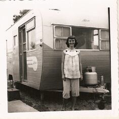 Mom, pregnant with George Jr., standing in front of their trailer. Many Pros traveled towing a trailer, staying in parks instead of hotels. Spring 1956...