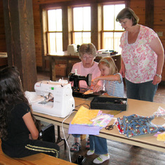 Grandma Ginny teaching her great-grandchildren to sew. July 2009