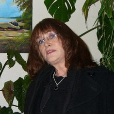 Glenda at home surrounded by beloved artwork and plants.