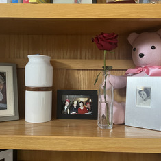 my mom's shelf with her urn and stuffed bear made from her robe.