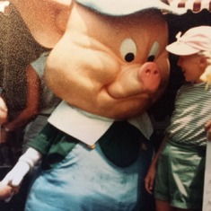 Greg counting the pig's fingers and Deborah seeing eye to eye with the pig. Disney World.