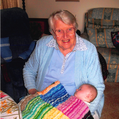 Helen and a bub with with a rug knitted by Helen