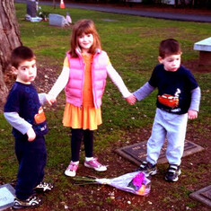 Olga's kids, Loukas, Tessa Eleni and Constantine, lay flowers on Lily's resting place on the anniversary of their grandma's loss.