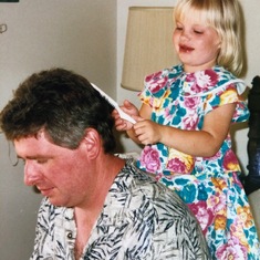 Uncle Henry, patient and accommodating, lets his niece style his hair.