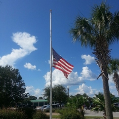 The flag flying at half-staff with a beautiful chrysanthemum in honor of Herb at our home at Hibiscus by the Bay, Panama City Florida
