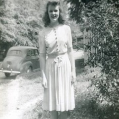 Young hilda standing outside with car in background