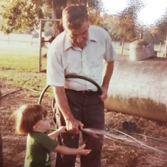 Jacob Larry Short with granpa J.C. Short at farm in Powderly, TX getting a drink of water from the well water hose.