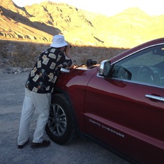 Jimmy leaning on our rental car photographing in Death Valley