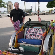 Jimmy in Penang with a colorful rickshaw.