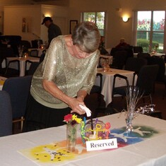 Joan helps prepare tables for a formal dinner at our UU