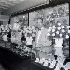 John Anstett standing behind counter in Anstetts 50s