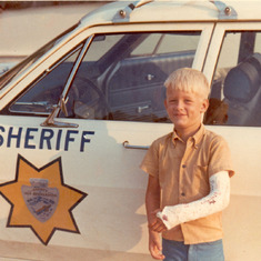 john_von_colln_~6yrsold_brokenarm_with Dad's (John) sheriff_car