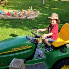 Luca riding on the lawn mower